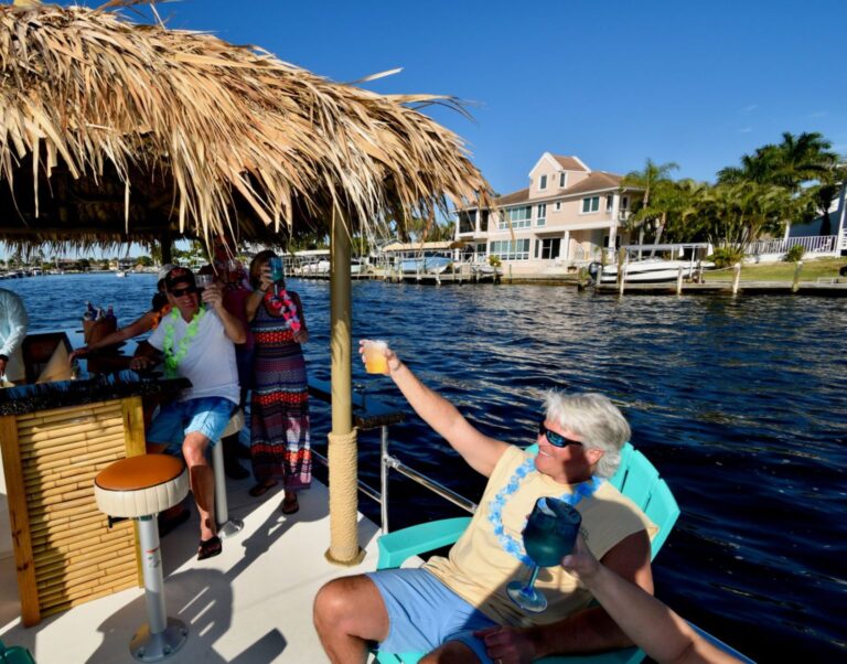 Man raises a glass to a toast on the Nautical Tiki boat