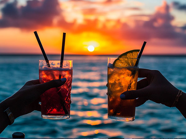 Couple toasting sunset aboard Nautical Tiki Cruises